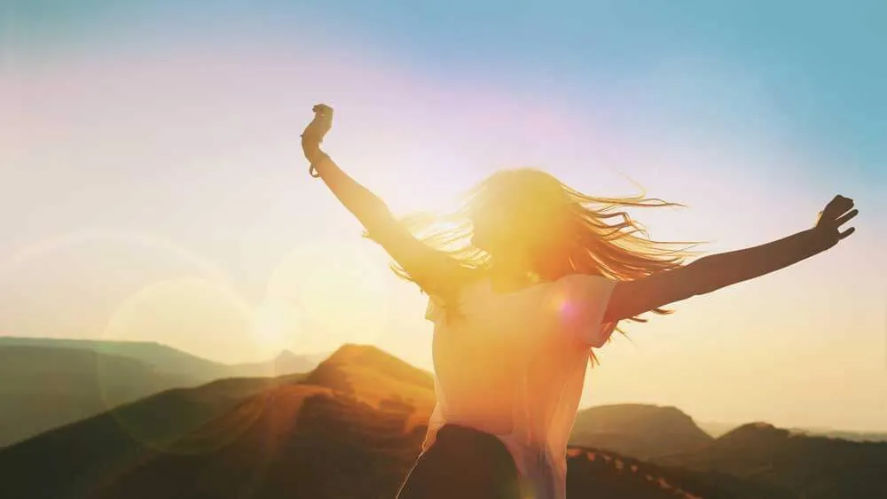 Woman celebrating with healthy, full hair after Thairapy by RESTORE®